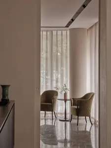 A modern living room featuring marble flooring and upholstered furniture made of fabric.