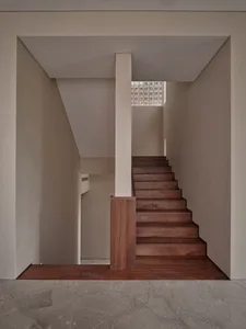Modern minimalist staircase with wooden steps in an interior space.