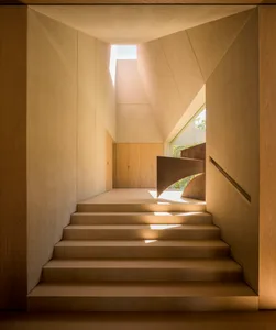 A modern staircase with concrete steps and wooden handrails.
