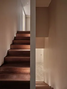 Modern staircase with dark wooden steps illuminated by soft, ambient lighting