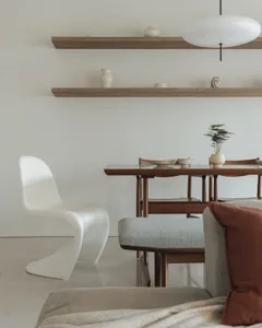 A minimalist living room with wooden furniture and a large circular window.