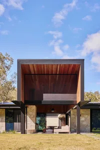 Modern house exterior featuring wooden and stone materials in a contemporary design style.