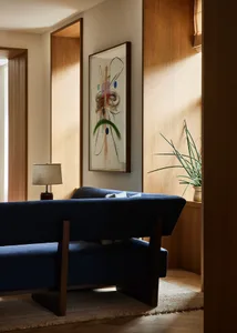 Modern living room featuring wooden furniture and a blue sofa.