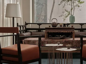 Modern living room featuring a combination of sleek, teak furniture and traditional decorative items, including a vase with g