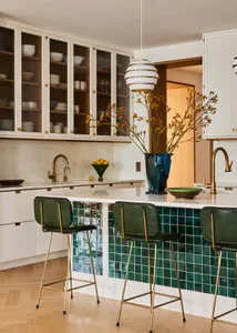 Modern, minimalist kitchen featuring green ceramic tile backsplash and marble countertops.
