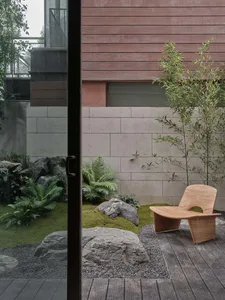 A minimalist landscape design featuring natural elements such as rocks, plants, and wooden furniture.