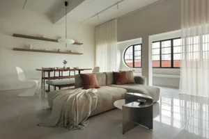 A modern living room with neutral-toned furniture and a minimalist design.