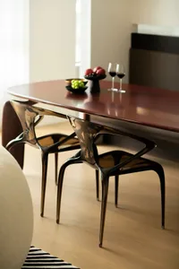 Modern dining room with minimalist black chairs at a sleek, polished wood table.