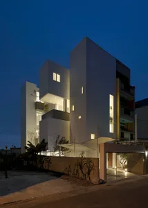 A modern exterior concrete house with illuminated windows at night.