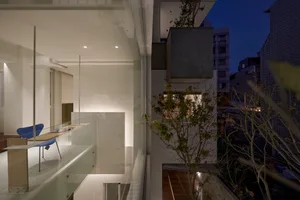 Modern residential interior features glass walls and light-filled spaces.