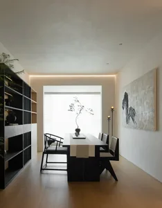 Modern living room with timber, metal, and glass furniture, minimalist decor, and large windows.