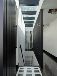 A modern interior design featuring glass ceiling, black columns, and marble flooring.