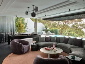 Contemporary living room featuring modern furniture, marble coffee table, and a scenic view of the pool.