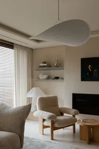 Minimalist modern living room with textured shelving and cozy seating arrangements.