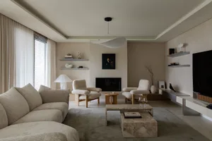 A modern, minimalist living room with neutral-colored furniture and materials.