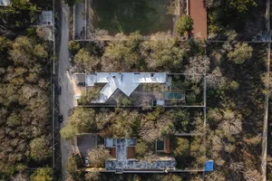 Aerial view of a modern residential building with a concrete facade and large glass windows.