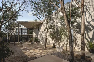 Modern residential concrete garden with a hammock hanging between trees.