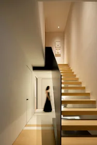A modern staircase with wooden steps and a glass railing