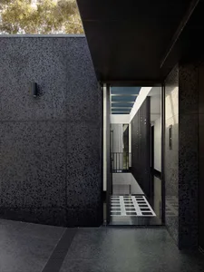 Modern entrance featuring terrazzo floor and black walls and ceiling