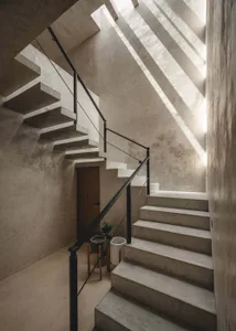 Minimalist interior with concrete staircase and skylight.