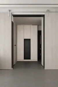 A modern minimalist bedroom featuring wooden cabinets and flooring.