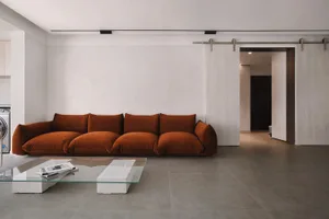 Modern, spacious living room featuring a sleek, minimalist design with rich colors, and large windows allowing natural light 
