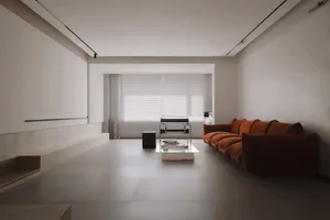 Modern minimalist living room featuring concrete flooring, glass wall, and sleek furniture.