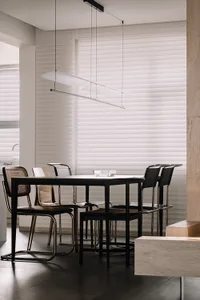 Modern kitchen with wood cabinets, metal fixtures, and glass accents.