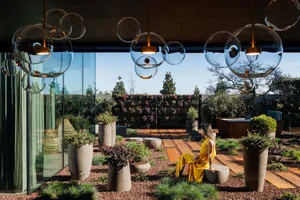 A modern interior featuring a living space with concrete and glass elements