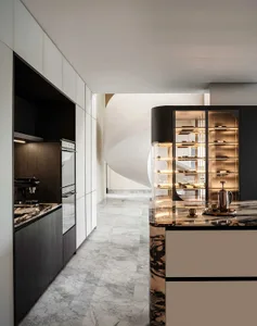 A modern kitchen with marble countertops and cabinets, featuring sleek appliances and a wine cabinet with illuminated shelves