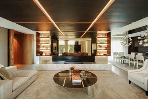 Modern living room with a circular glass coffee table, minimalist decor, and open-plan design, featuring a combination of woo
