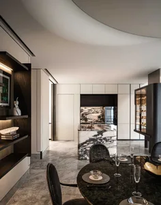 Modern minimalist kitchen with marble countertops and white cabinets.