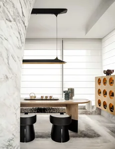 A minimalist tea room featuring a wooden table, marble walls, and ceramic tea set.