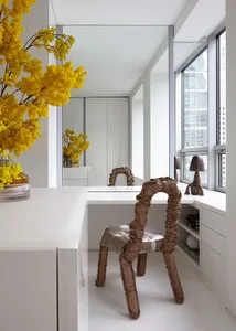Modern, minimalist residential interior with metallic upholstery on a unique, abstract-shaped chair.