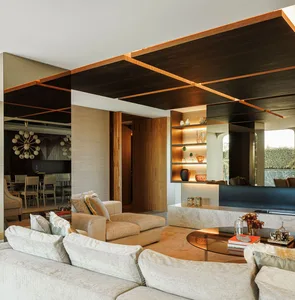 A modern living room with concrete walls, featuring a couch, chairs, and a coffee table with decorative items.