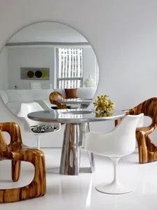 A modern living room with sleek, wooden furniture and a round, polished table.