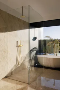 Modern minimalist bathroom designed with marble elements and a spacious tub with a view of the outdoors.