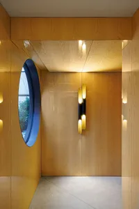 A minimalist interior design featuring wood panels and a circular window.
