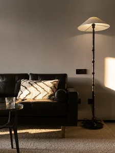 A modern black leather sofa with a throw pillow in a living room setting.