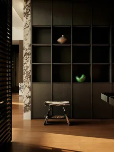 A modern interior design featuring a mix of dark wood furniture, marble accents, and minimalist decor.