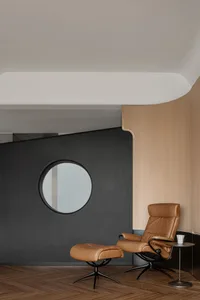 A modern living room with a comfortable brown leather recliner and matching ottoman