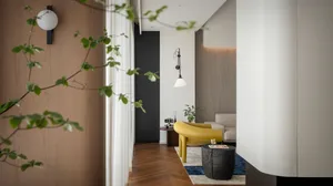 Modern living room with wooden floor, white walls, and yellow chair.