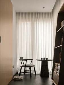 A modern living room featuring wooden furniture and fabric curtains.