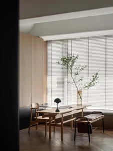 A minimalist interior featuring wooden furniture, glass accents, and leather seating.