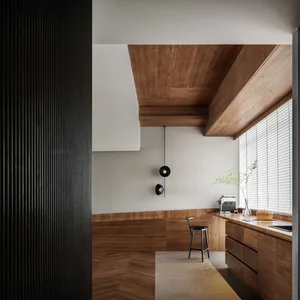 A modern residential kitchen designed with wood materials and minimalist design.