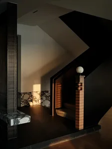 Modern staircase with marble flooring, wood accents, and intricate metalwork.