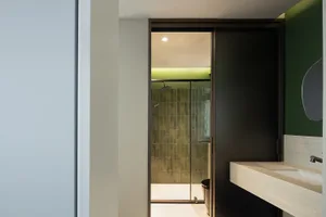 Modern bathroom featuring glass shower enclosure and tile walls