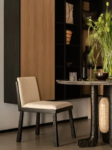 A modern black dining chair with a beige upholstered seat and cushioned backrest.