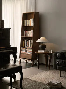 Modern living room with wooden bookshelf, lamp, and piano.