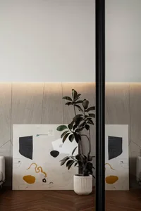 A modern minimalist interior design featuring abstract artwork with geometric shapes on a white, textured background, complem